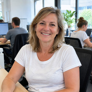 Frau sitzt im T-Shirt im Büro