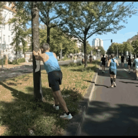 Läufer lehnt beim Marathon erschöpft an einem Baum – der Mann mit dem Hammer